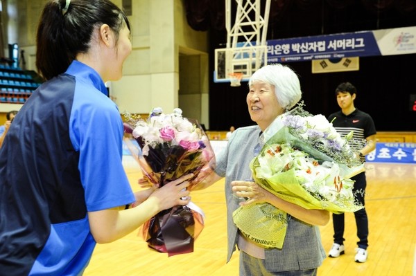  2015년 박신자컵 ‘서머리그’에서 박지수(청주 KB)에게 꽃다발을 건네고 있는 모습  [WKBL 제공]
